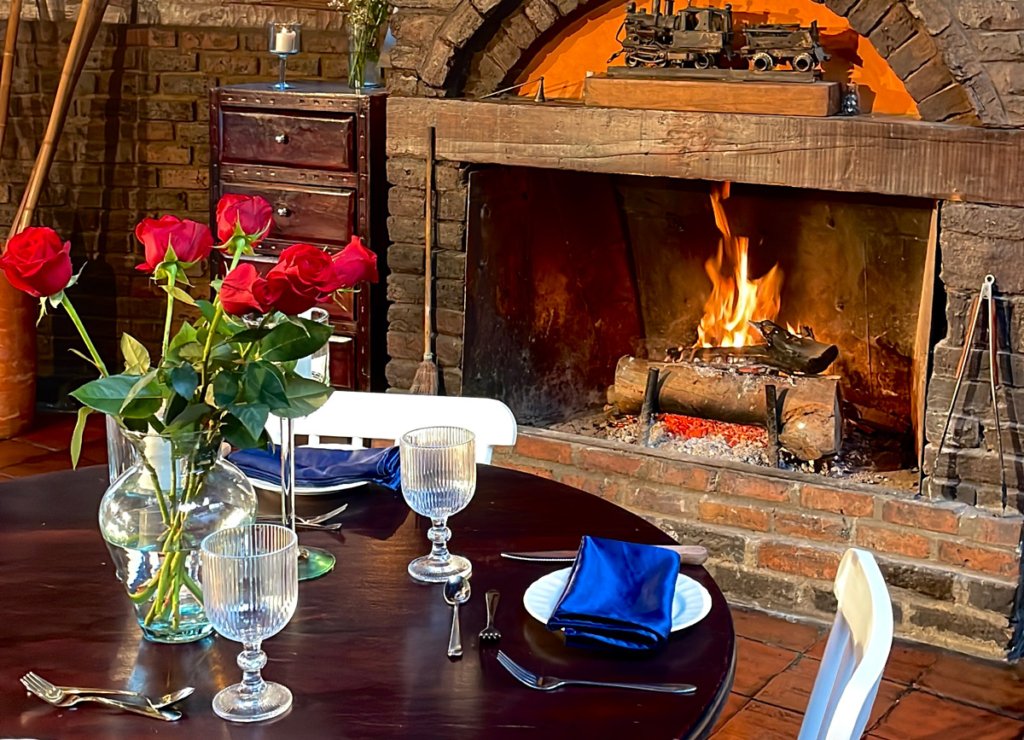 Mesa decorada con flores al lado de una chimenea
